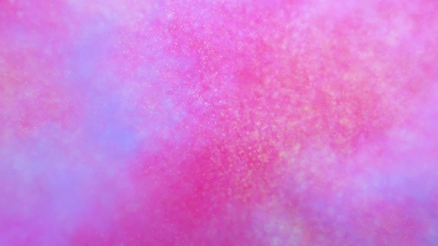由多种彩色粉末制成的径向圆形状向相机爆炸，在粉色背景上散焦，闪闪发光视频下载