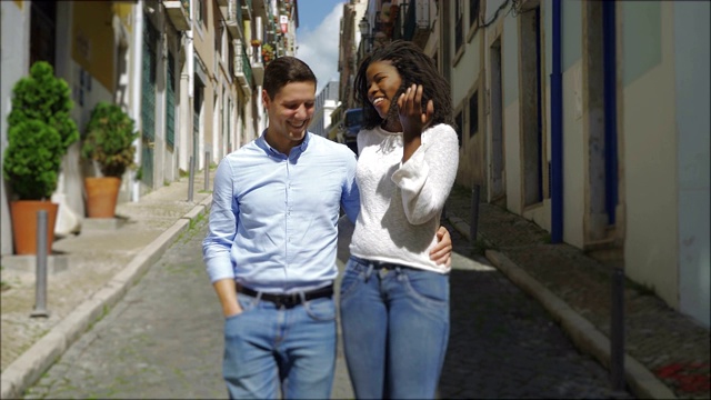 面带微笑的跨种族情侣在街上聊天。视频下载