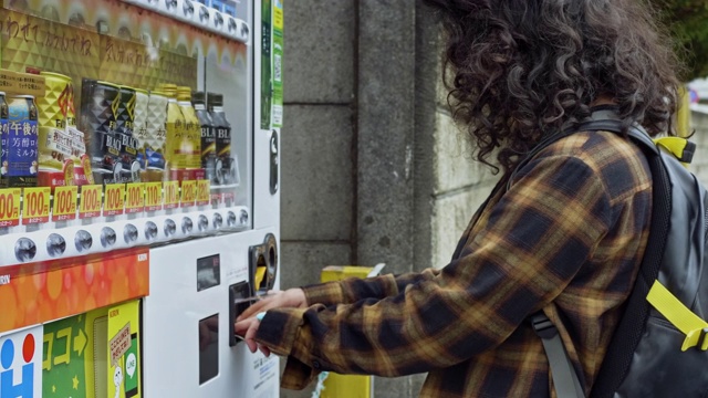 年轻的亚洲女孩在自动售货机里买饮料视频下载