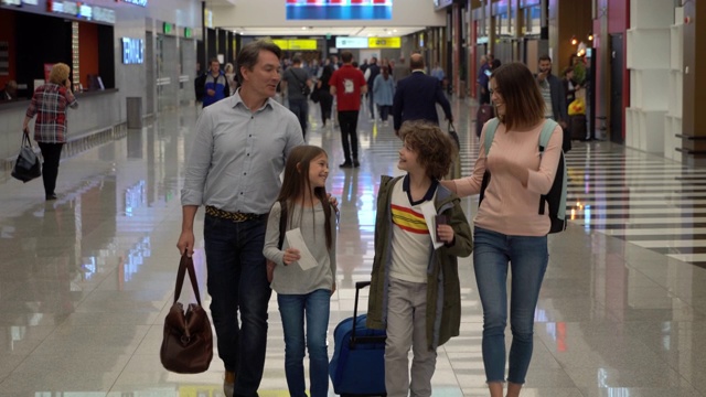 美丽的一家人带着行李走过机场拿着护照和登机牌聊天视频下载