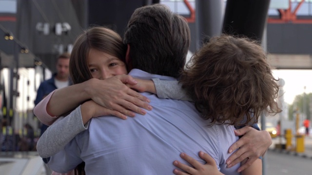 兴奋的一家人在机场拥抱爸爸的特写镜头视频下载