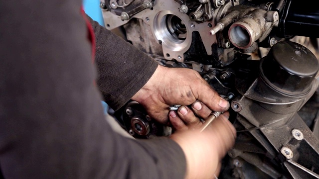 特写机械师修理汽车的引擎，他移开引擎头。视频素材