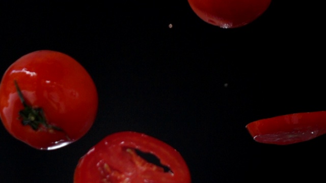 黑色背景上的番茄坠落慢动作视频素材