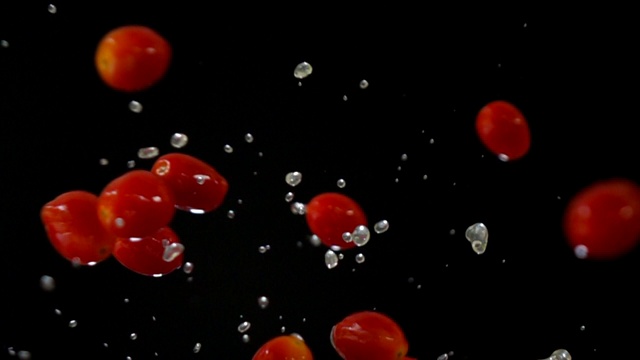 黑色背景上的番茄坠落慢动作视频素材