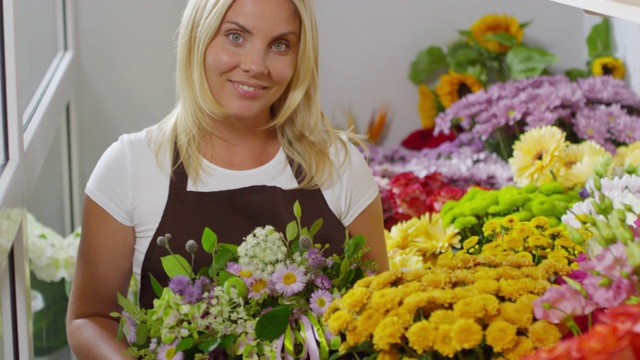 开心的花商摆出五颜六色的花的姿势视频素材