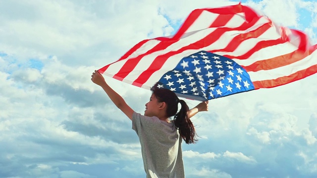 快乐的亚洲小女孩与美国国旗美国庆祝7月4日视频下载