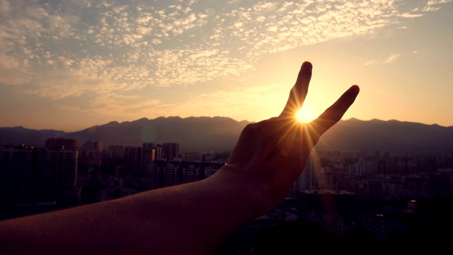 夕阳西下，手指做着和平的手势视频下载