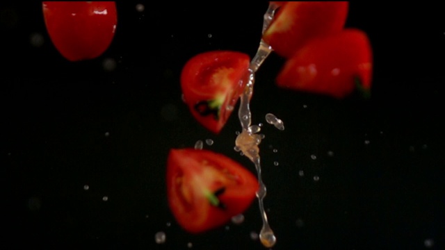 红色番茄倒在黑色背景的慢动作视频素材