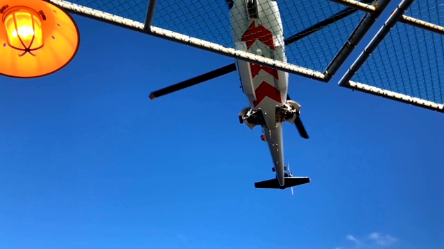 直升机慢速降落在油气平台的直升机甲板上，运送人员或乘客到海上油气行业工作，空运支持乘客。视频下载