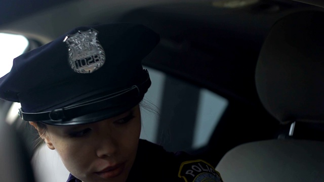 亚洲女警察进入警车，准备驾驶，占领视频素材