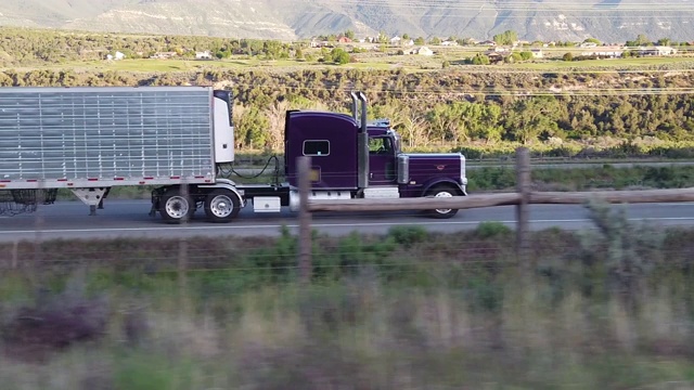 日落时分，一辆半挂车在科罗拉多高速公路上行驶的视频剪辑视频下载