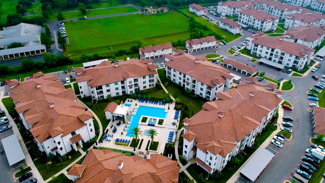 无人机俯瞰公寓大楼，橙色屋顶和现代游泳池视频下载