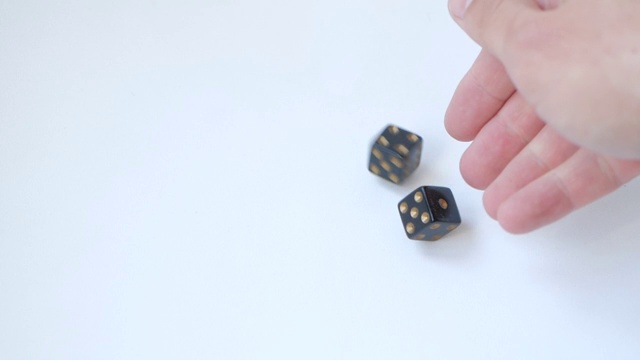 用一对黑色骰子在一张白色的桌子上以慢动作掷出1和5视频下载