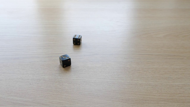 用一对黑色骰子在桌子上以慢动作掷出3和6视频素材