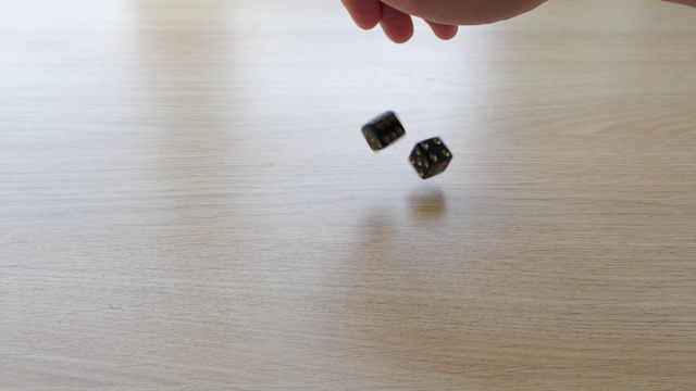 用慢动作在桌子上滚动一对黑色骰子视频素材