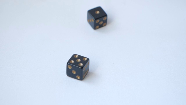 用一对黑色骰子在一张白色的桌子上用慢动作掷出5和1视频素材
