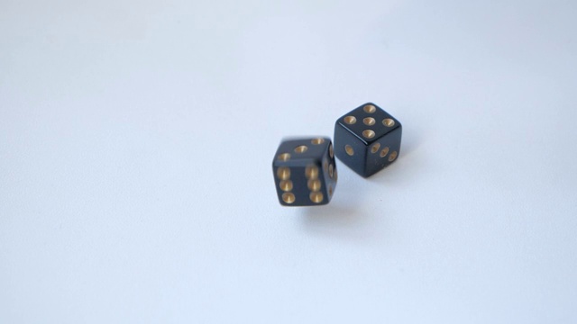 两个黑色的骰子在白色的桌子上以慢动作掷出一对5视频素材