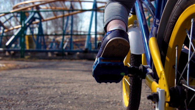 孩子们在旧公园里踩着蓝色的自行车。视频下载