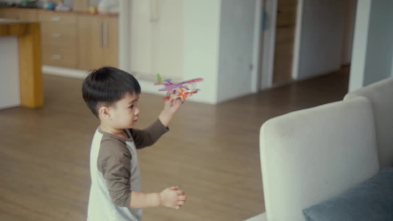 亚洲男孩拿着玩具飞机跑来跑去(慢镜头)视频下载
