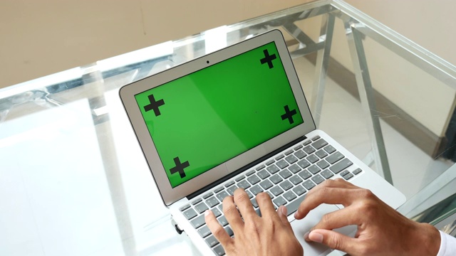 商人用绿色屏幕在笔记本电脑上打字视频素材