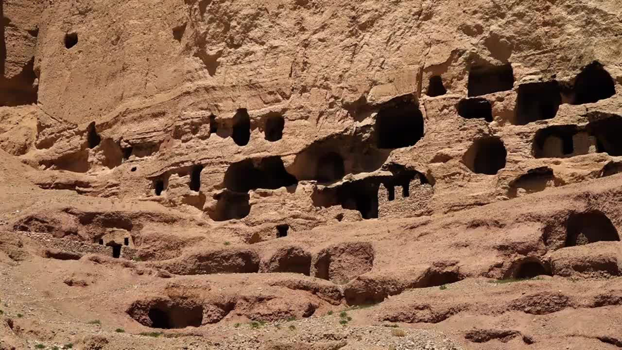 在巴米扬大佛所在地的悬崖上雕刻的洞穴开口的正面。视频下载