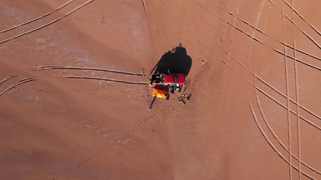 从空中俯瞰沙漠中的一站，帐篷营地，火和一辆全轮驱动的汽车，在世界上最干燥的沙漠阿塔卡马沙漠进行惊人的冒险。令人敬畏的干旱气候景色视频下载