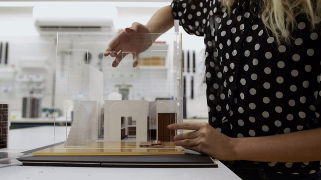 建筑设计办公室的工人用建筑的塑料模型视频下载