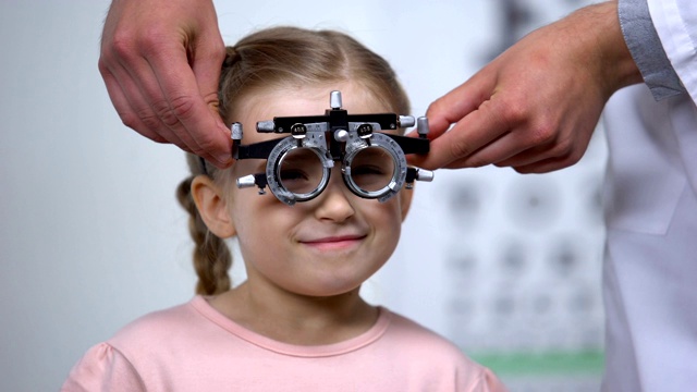 验光师给小女孩戴上特制眼镜，诊断弱视眼病视频素材