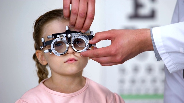 孩子说不，医生就在光测仪上更换镜片，寻找合适的屈光度视频素材