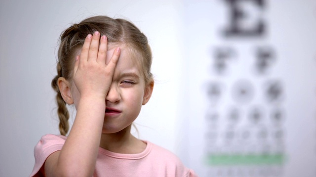 可爱的孩子闭上一只眼睛测试视力，诊断视力疾病视频素材