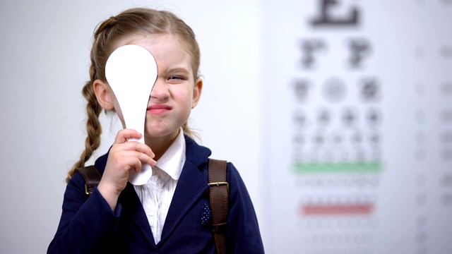 女学生闭上一只眼睛作全面视力检查，视力诊断视频素材