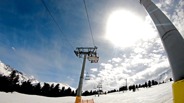 带座椅的滑雪缆车将滑雪者和滑雪板运送到山坡上，慢动作视频素材