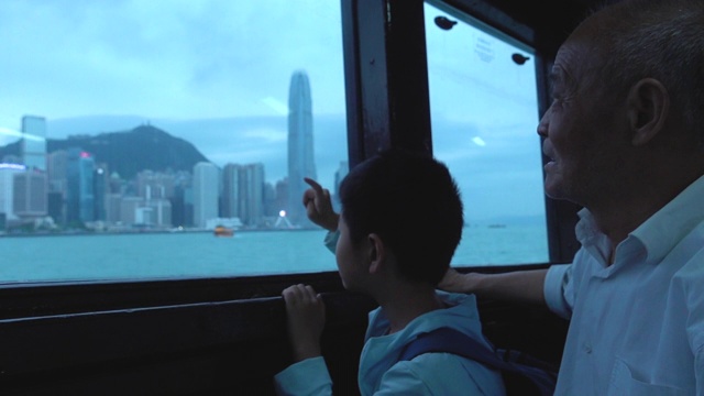 爷爷和孙子坐渡轮看香港的天际线视频下载