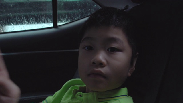 坐在车里看外面的亚洲男孩视频素材