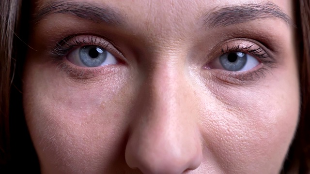 特写的成年白人女性的脸与蓝色眼睛被关闭，打开和直视相机视频素材