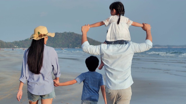 幸福的一家人在海滩上散步。快乐的一家人在海滩上享受暑假。假期——iStock视频素材
