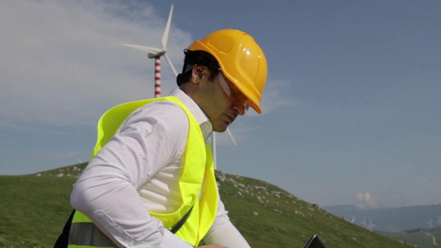 身穿黄色背心、头戴安全帽的男性风力涡轮机工程师视频素材