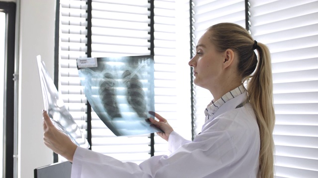 女医生观看并比较MRI肺扫描视频素材