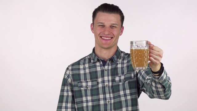 英俊的年轻人开心地笑着，拿着他的啤酒对着镜头视频下载