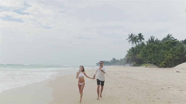 一对浪漫的情侣在海滩上玩耍视频素材