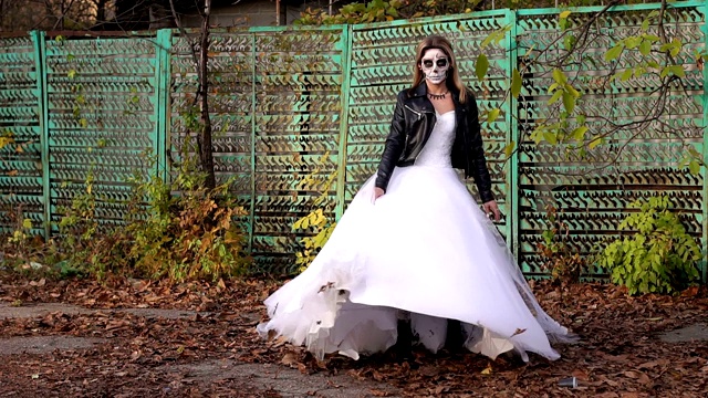 女孩穿着婚纱和一个可怕的化妆纺纱在秋天。万圣节视频素材