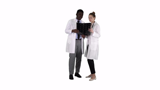 严肃友善的女医生和非裔美国医生在白色背景下研究脑部x光片视频素材