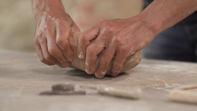 男性陶艺家的特写造型和塑造粘土在桌子上。制作手工陶瓷制品。视频下载