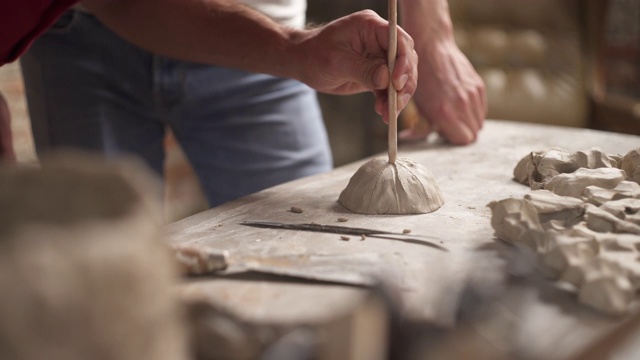 专业陶工用特殊工具制作陶土，并向学生展示他的作品。教师与追随者一起工作的概念。视频下载