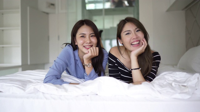 两个美丽的台湾女人躺在床上笑视频下载