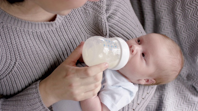 年轻的母亲用奶瓶喂她的婴儿视频下载