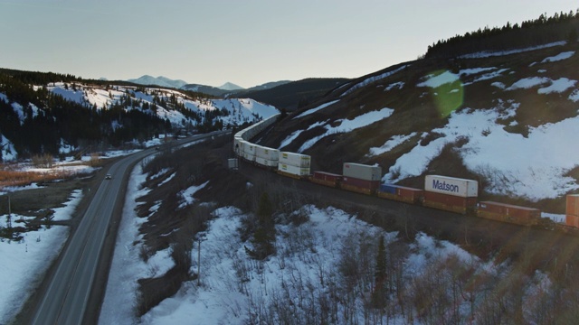在落基山脉靠近冰川国家公园的货运火车-空中视频下载