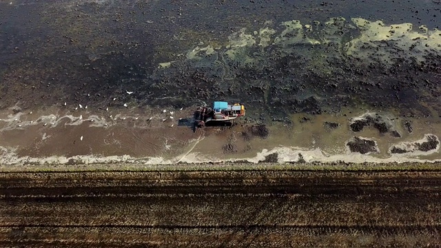 拖拉机在稻田前用犁犁地的鸟瞰图视频素材