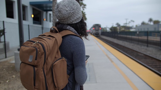 一个年轻女子在车站等火车视频素材