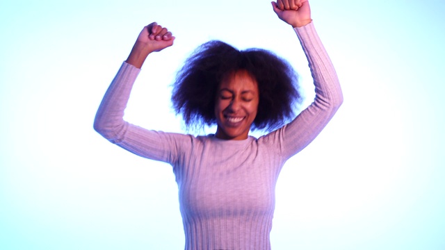 受启发的酷的非裔美国妇女跳舞感觉音乐和享受生活在蓝色穆迪霓虹灯迪斯科灯光的背景。在人，音乐节，青年派对之夜的生活方式。视频素材